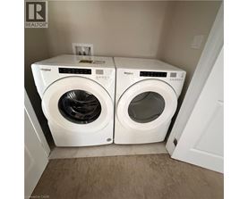 Two white Whirlpool washing machines in a small laundry room.