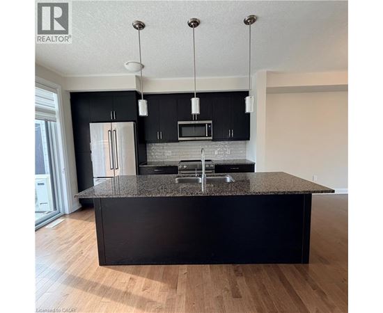 A modern kitchen with black cabinets and a granite countertop.