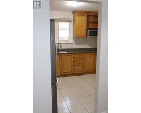 A kitchen with wooden cabinets and a refrigerator.