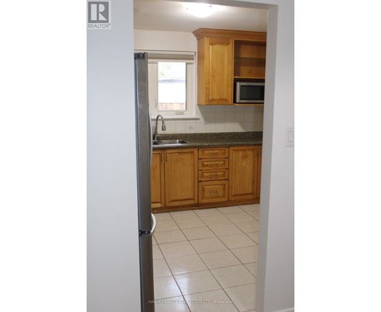 A kitchen with wooden cabinets and a refrigerator.