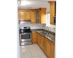 A kitchen with wooden cabinets and a stainless steel oven.