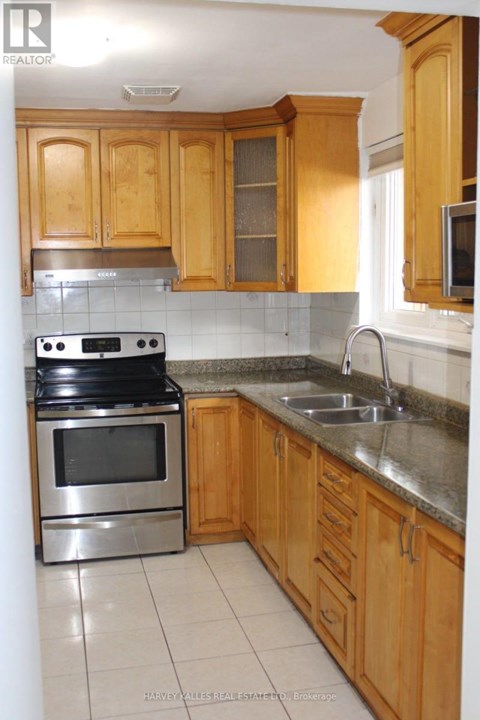 A kitchen with wooden cabinets and a stainless steel oven.