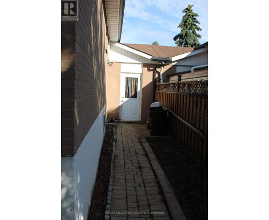 A white door is on the left side of a brick building.