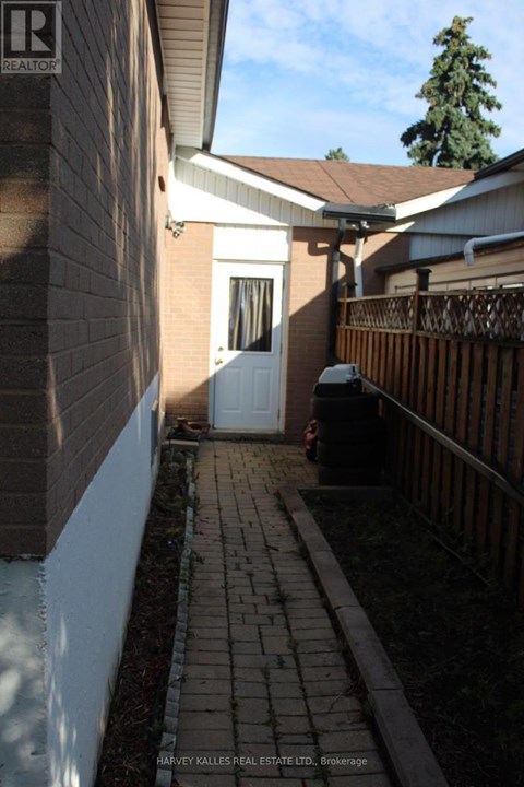 A white door is on the left side of a brick building.