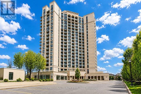 A tall building with a parking lot in front of it.