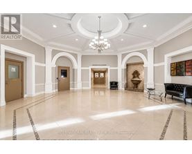 A spacious lobby with marble floors and a chandelier.