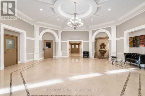 A spacious lobby with marble floors and a chandelier.