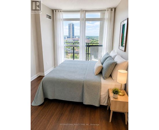 A bedroom with a large bed and a view of the city.