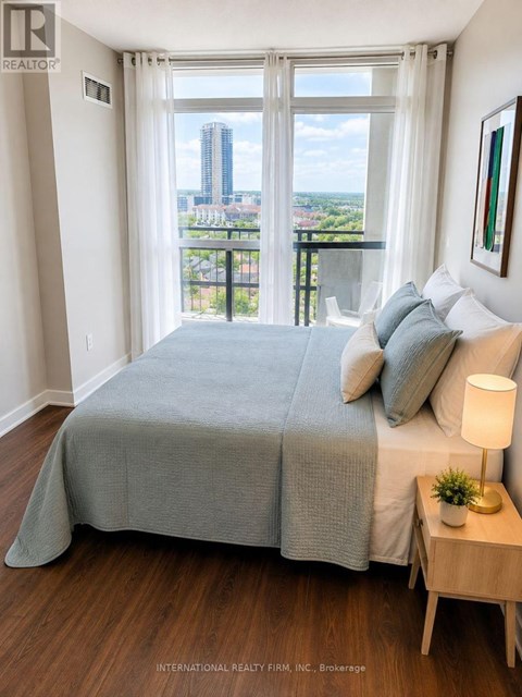 A bedroom with a large bed and a view of the city.
