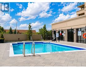 A swimming pool with a ladder and a building in the background.