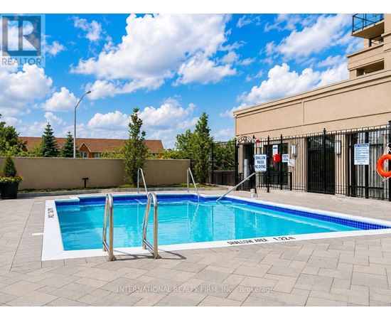 A swimming pool with a ladder and a building in the background.