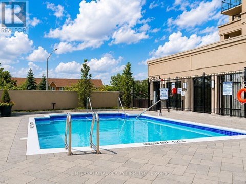 A swimming pool with a ladder and a building in the background.