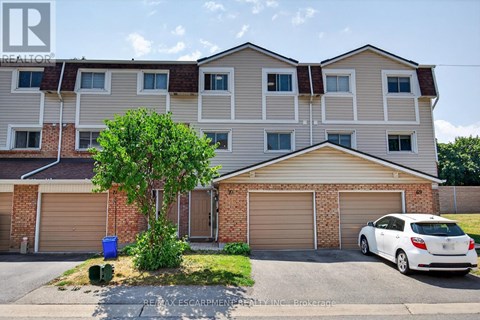 A white car is parked in front of a two-story apartment building.