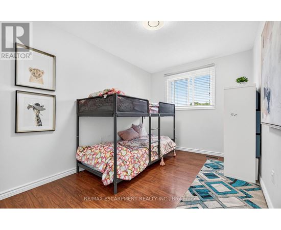 A bedroom with two bunk beds and a rug on the floor.