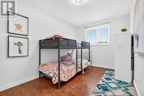 A bedroom with two bunk beds and a rug on the floor.
