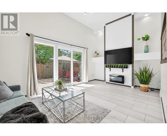 A living room with a glass coffee table and a grey sofa.