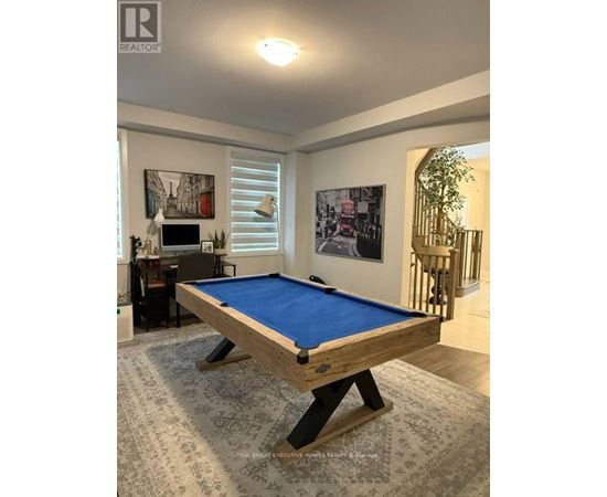 A pool table in a room with a painting on the wall.