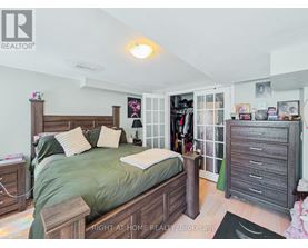 A bedroom with a bed, nightstand, and a wardrobe.