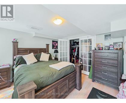 A bedroom with a bed, nightstand, and a wardrobe.