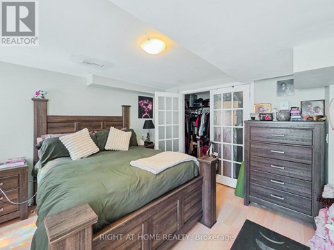 A bedroom with a bed, nightstand, and a wardrobe.