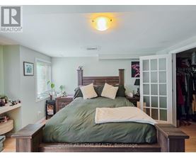 A bedroom with a bed in the center and a wooden headboard.