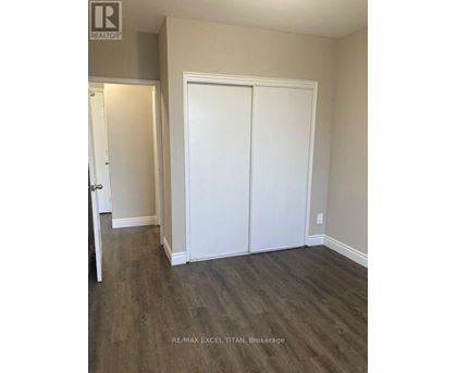 A room with a white door and a white closet with a wood floor.