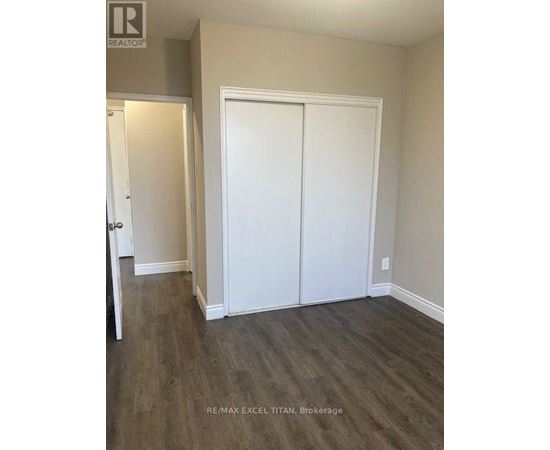 A room with a white door and a white closet with a wood floor.