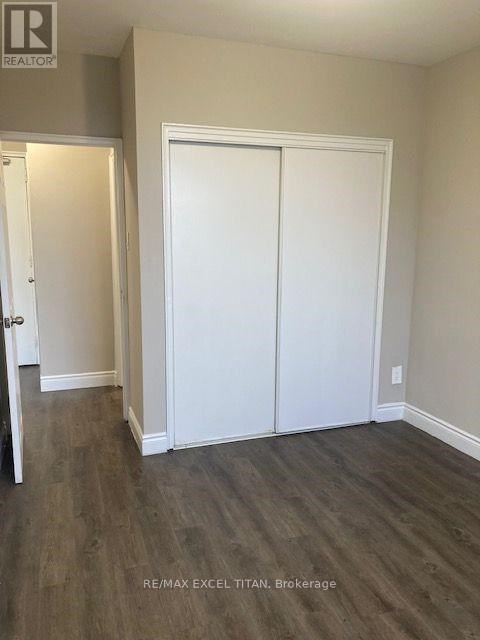 A room with a white door and a white closet with a wood floor.