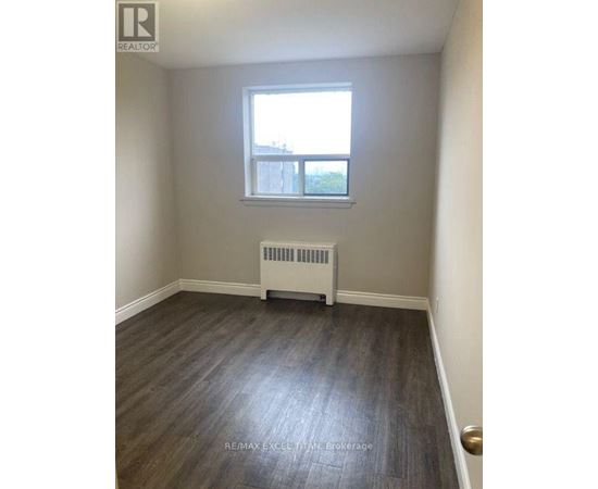 A room with a window and a radiator on the floor.