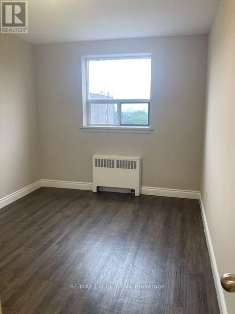 A room with a window and a radiator on the floor.
