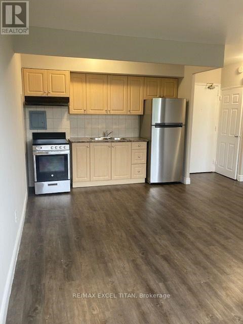 A kitchen with wooden cabinets and a stainless steel refrigerator.