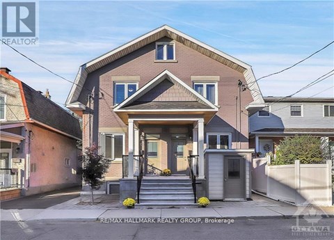 A house with a front yard and a sign that says RE/MAX Hallmark Realty Group, Brokerage.