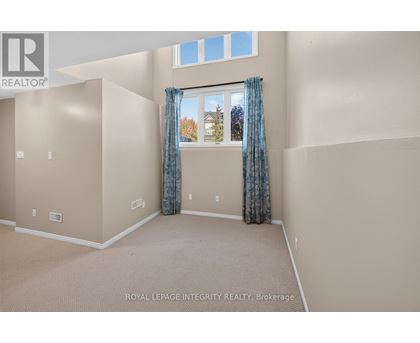 A room with beige walls and a window with blue curtains.