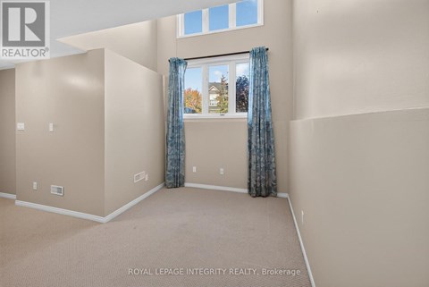 A room with beige walls and a window with blue curtains.