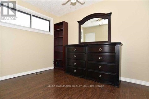 A bedroom with a large wooden dresser and a mirror.