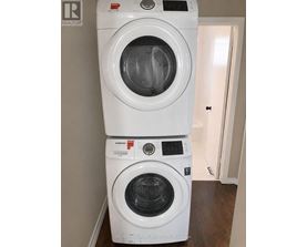A stack of two white front loading washing machines.