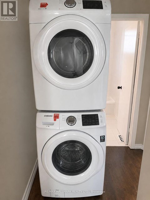 A stack of two white front loading washing machines.