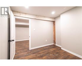 A room with a doorway leading to another room and a brick wall on the side.