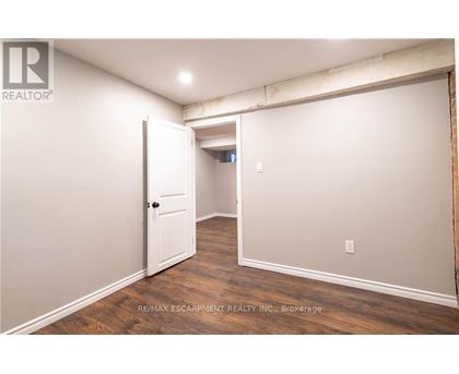 A room with a white door and wooden flooring.