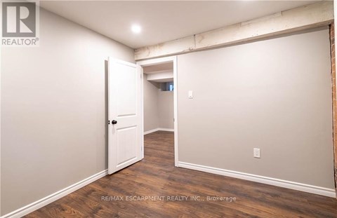 A room with a white door and wooden flooring.