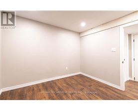 A room with wooden flooring and white walls.