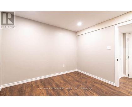 A room with wooden flooring and white walls.