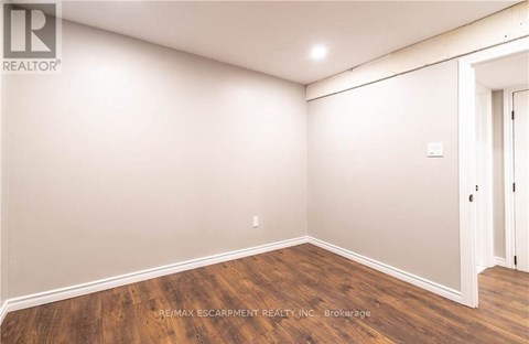 A room with wooden flooring and white walls.