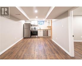 A kitchen with wood flooring and a refrigerator, oven, and microwave.