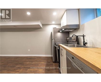 A kitchen with a wooden counter top and stainless steel appliances.