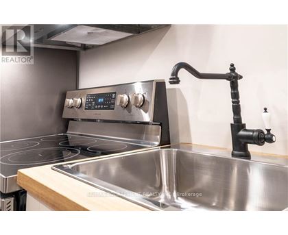 A modern kitchen with a stainless steel oven and sink.