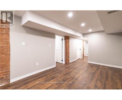 A spacious room with wooden floors and white walls.