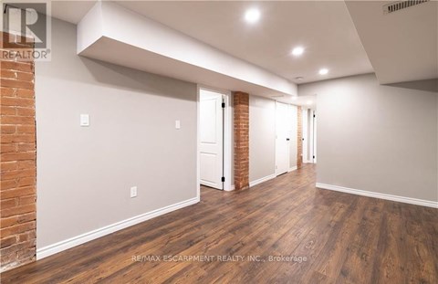 A spacious room with wooden floors and white walls.