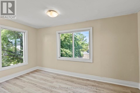A room with a window and a wooden floor.
