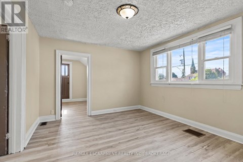 A room with a window and a wooden floor.